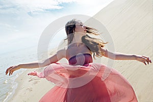 Woman in red waving dress with flying fabric, Beautiful girl spinning with outstretched arms