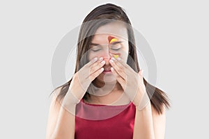 Woman in red wear feeling unwell because of sinus against a gray background. People caught a cold and fever.