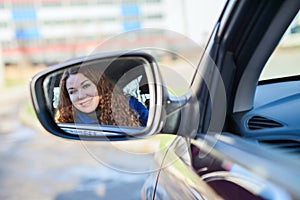 Woman reflection in car back rear-view