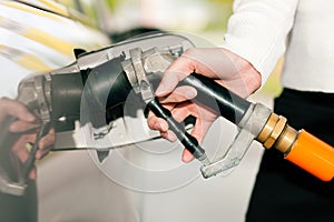 Woman refueling car with LPG gas photo