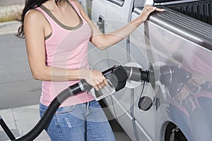 Woman Refueling Her Car At A Fuel Station photo