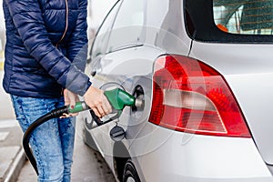 Woman refueling her small silver car