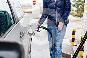 Woman refueling her small silver car