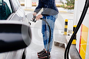 Woman refueling her small silver car