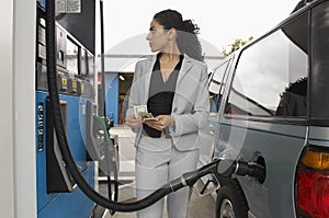 Woman Refuelling Car At Petrol Pump