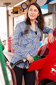 Woman refuelling a car at a petrol station