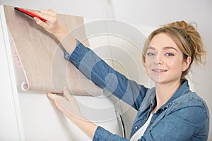 woman refurbishing kitchen cupboard