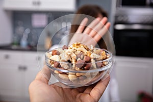 Woman Refusing Bowl Of Nut Food