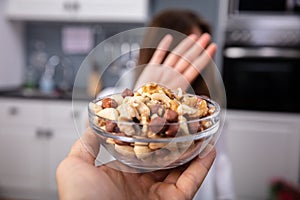 Woman Refusing Bowl Of Nut Food photo