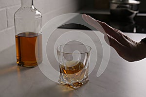 Woman refusing to drink whiskey indoors, closeup. Alcohol addiction treatment