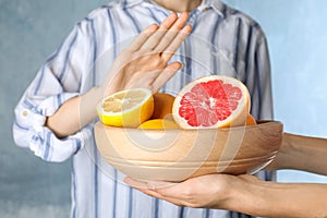 Woman refusing to eat citrus fruits. Food allergy concept photo