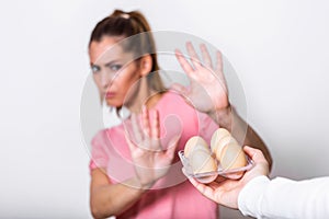 Woman refusing to eat eggs. Egg Free Affected Allergy Banned Restriction. Young beautiful woman holding fresh egg at home with