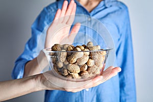 Woman refusing to eat peanuts. Food allergy concept photo