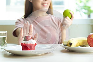 Woman refusing to eat sweet bakery or cake during diet session for slim shape and good health