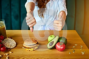 Woman is refusing to eat unhealthy hamburger. Cheap junk food vs healthy diet