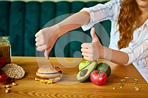 Woman is refusing to eat unhealthy hamburger. Cheap junk food vs healthy diet