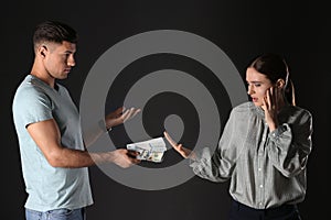 Woman refusing to take bribe on black background