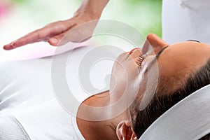 Woman at reiki session with therapist hand in background. photo