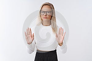 Woman rejects disrespectful offer. Upset and displeased gloomy blond female businesswoman in glasses and cropped sweater photo