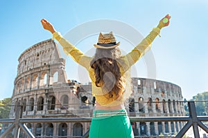 Woman rejoicing in front of colosseum in rome