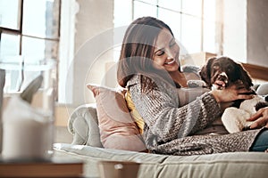 Woman relax on couch, relax and content at home with pet.and happy together with peace and care in living room. Happy