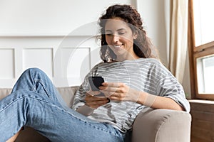 Woman relaxing at home with smartphone spend time on internet