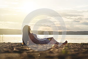 Woman relax and lay down in the sunset on the beach.