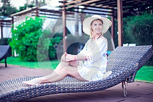 Woman relax near swimming pool sunbath at the beach resort in th