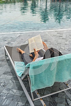 Woman relax and reading book at swimming pool on vacation
