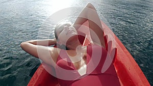 Woman, relax and sleeping on boat, river and sunshine for adventure, holiday and outdoor on water. Girl, kayak and tired