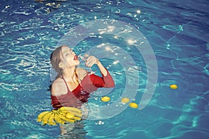 Woman relax in spa pool. woman with tropical fruit in pool. Vitamin in banana at girl sitting near water. Dieting and