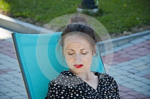 Woman relax on summer sunbed outdoor. Summer vacation. Summertime at poolside. Girl relax in sunbed in the park. Vacation in