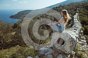 Woman relax in yoga pose at ruins of Delikkemer aqueduct