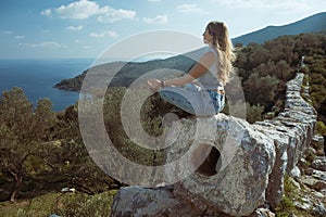 Woman relax in yoga pose at ruins of Delikkemer aqueduct