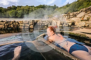 Woman relaxes and enjoys natural hot thermal water roman spa