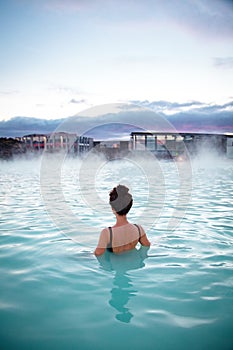 Woman relaxes and enjoys of spa in hot spring Blue Lagoon in Ice