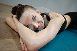 Woman relaxes and rests on a mat, a break in the gym