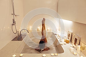 Woman relaxing in bath with candles