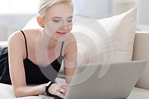 Woman relaxing on the bed with laptop