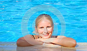 Woman relaxing in blue outdoor swimming waterpool