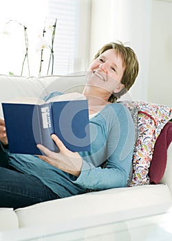 Woman relaxing with book at home