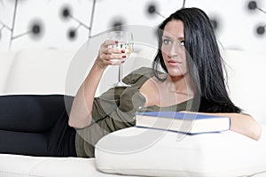 Woman relaxing with a book and wine