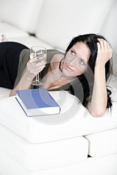 Woman relaxing with a book and wine