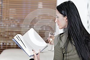 Woman relaxing with a book and wine