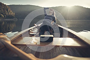 Woman relaxing in the canoe with wine