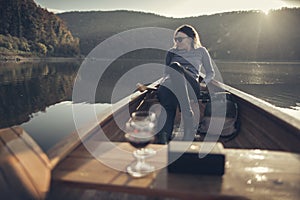 Woman relaxing in the canoe with wine