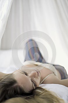 Woman relaxing in canopy bed