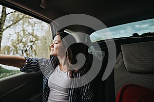 Woman relaxing in a car on a road trip enjoying the view