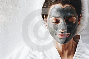 Woman relaxing with a charcoal facial mask