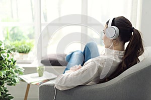 Woman relaxing on the couch and listening to music